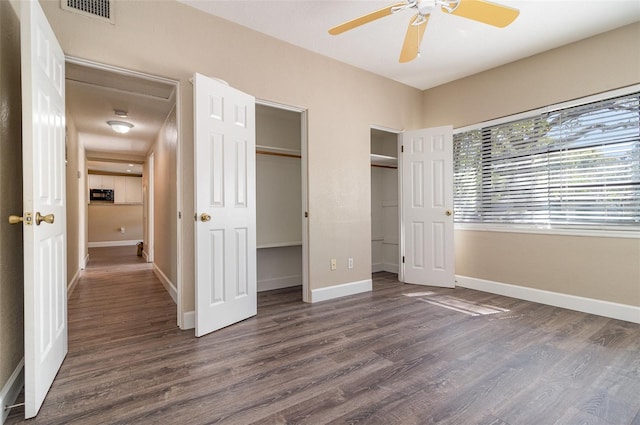 unfurnished bedroom featuring dark wood-style floors, visible vents, and baseboards