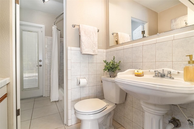 bathroom featuring tile patterned flooring, tile walls, toilet, and shower / tub combo with curtain