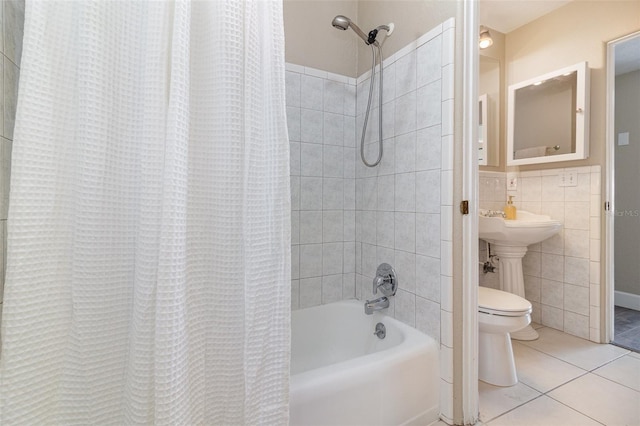 full bath with toilet, shower / bathtub combination with curtain, tile patterned floors, tile walls, and a sink