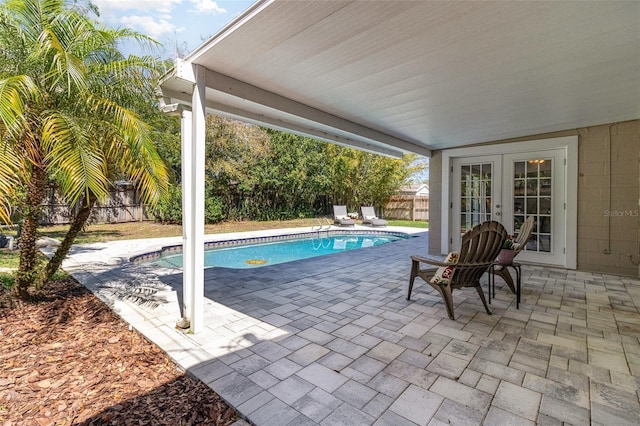 view of pool with french doors, a fenced in pool, a fenced backyard, and a patio area