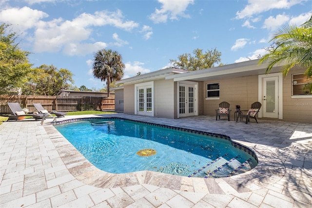 view of swimming pool featuring a fenced in pool, french doors, a patio, and fence