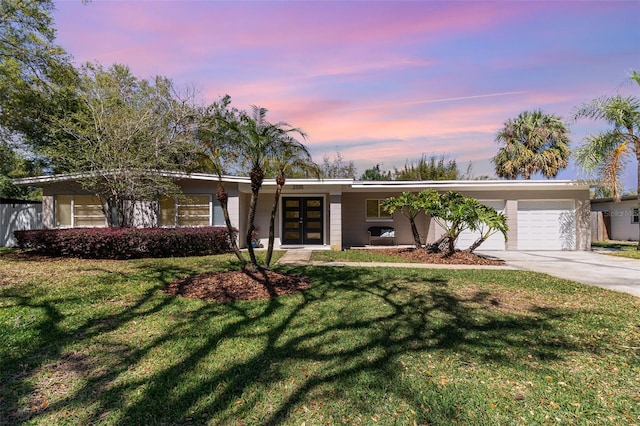 view of front of property with a front lawn, french doors, a garage, and driveway