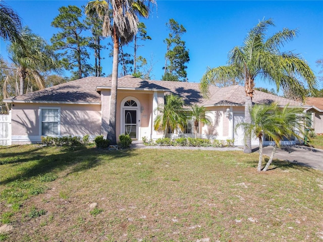 view of front of property with a front lawn, an attached garage, driveway, and stucco siding