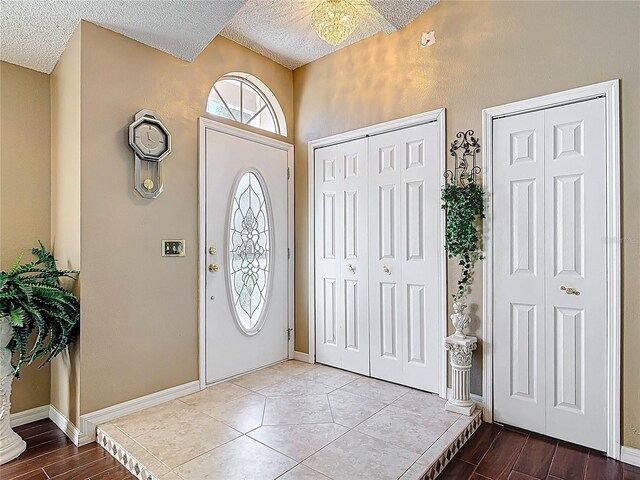 entrance foyer with wood finished floors, baseboards, and a textured ceiling