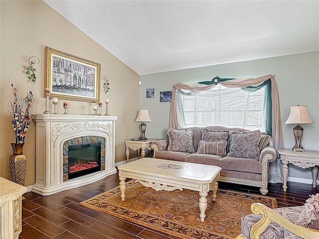 living area with lofted ceiling, a textured ceiling, a glass covered fireplace, baseboards, and wood tiled floor