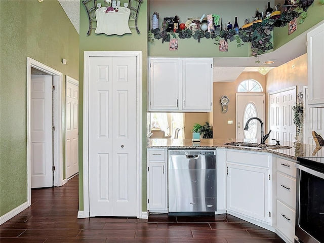 kitchen with stainless steel dishwasher, wood finish floors, white cabinetry, and a sink