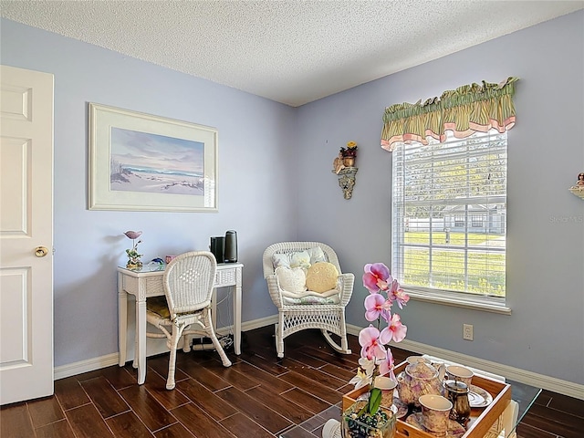 office area with a textured ceiling, baseboards, and wood tiled floor