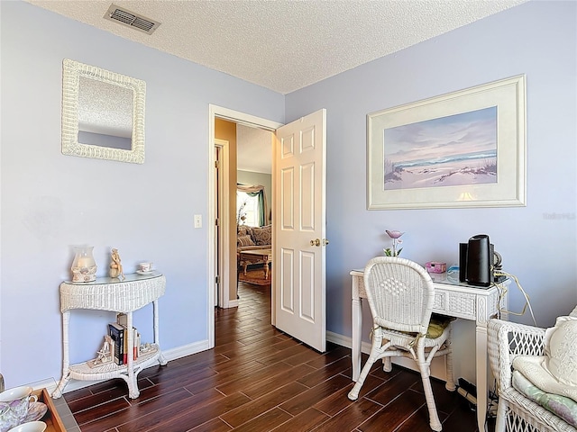 office space with visible vents, baseboards, a textured ceiling, and dark wood-style floors