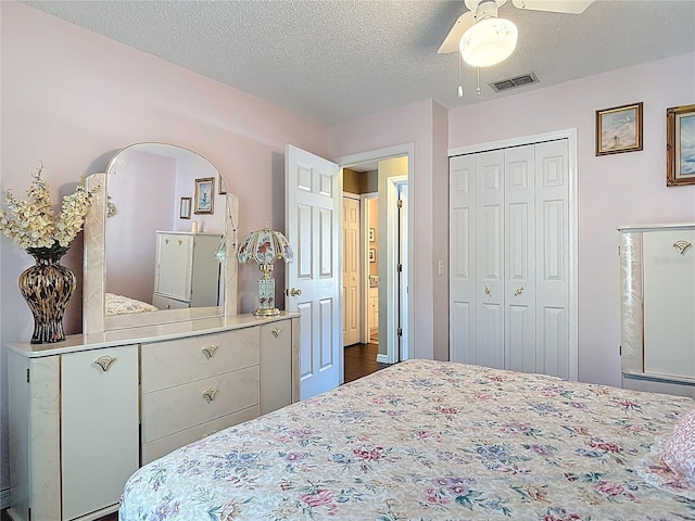 bedroom with a ceiling fan, visible vents, a closet, and a textured ceiling