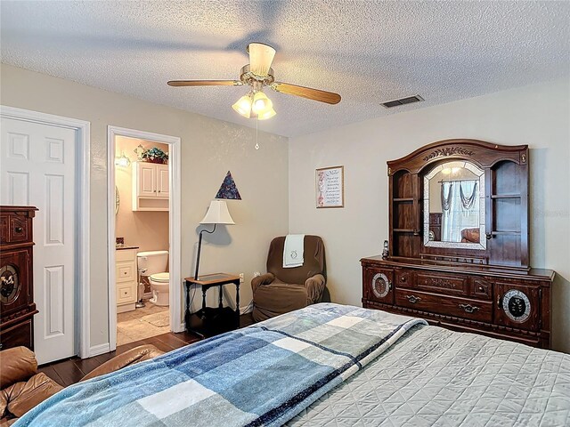 bedroom featuring a ceiling fan, wood finished floors, visible vents, a textured ceiling, and connected bathroom