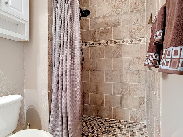 bathroom with a shower stall and toilet