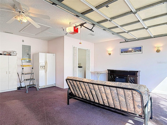 carpeted bedroom with electric panel, a garage, white fridge with ice dispenser, washer / clothes dryer, and a ceiling fan