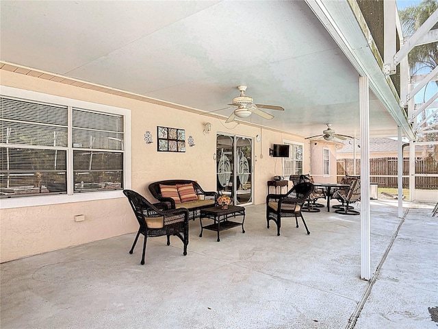 view of patio featuring fence, glass enclosure, outdoor lounge area, outdoor dining area, and ceiling fan