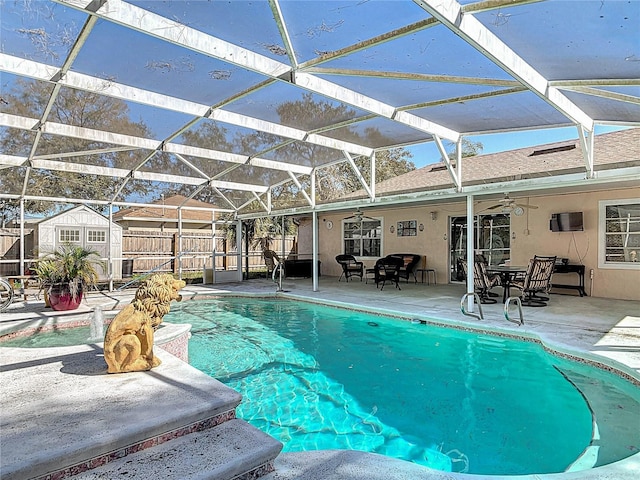 pool with a lanai, a patio, an outbuilding, and ceiling fan