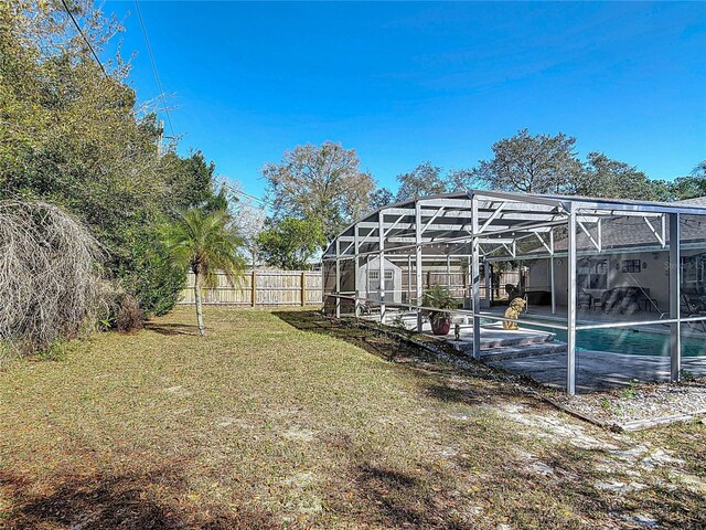 view of yard with glass enclosure, a fenced in pool, and fence