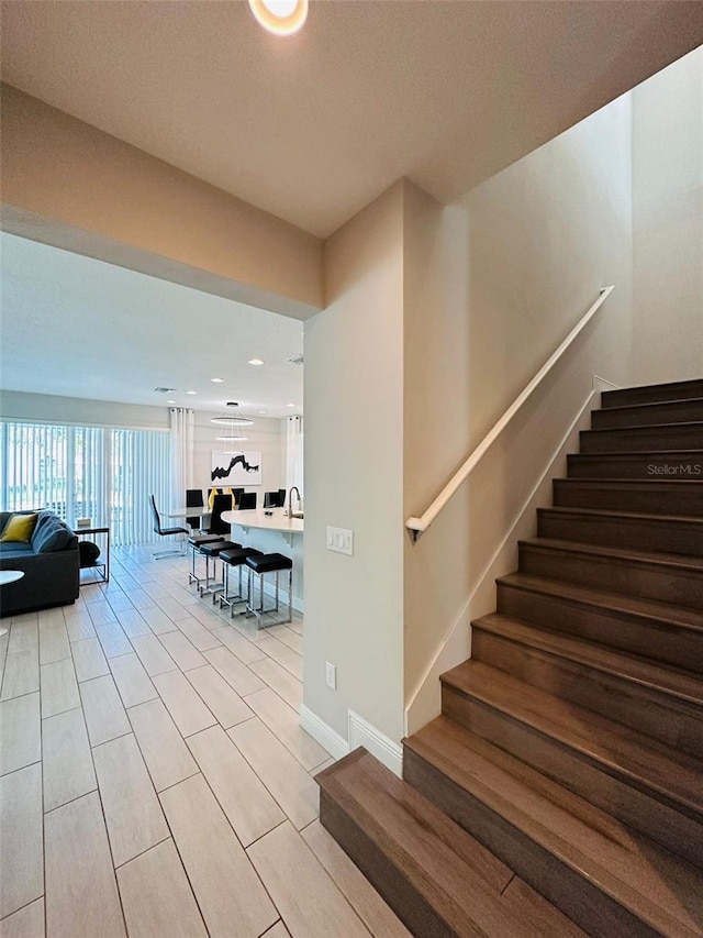 staircase featuring baseboards and wood finished floors