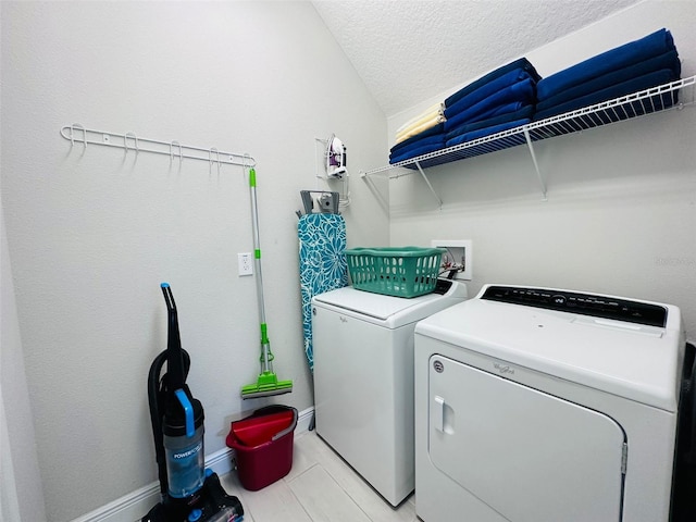 washroom featuring a textured ceiling, laundry area, and separate washer and dryer