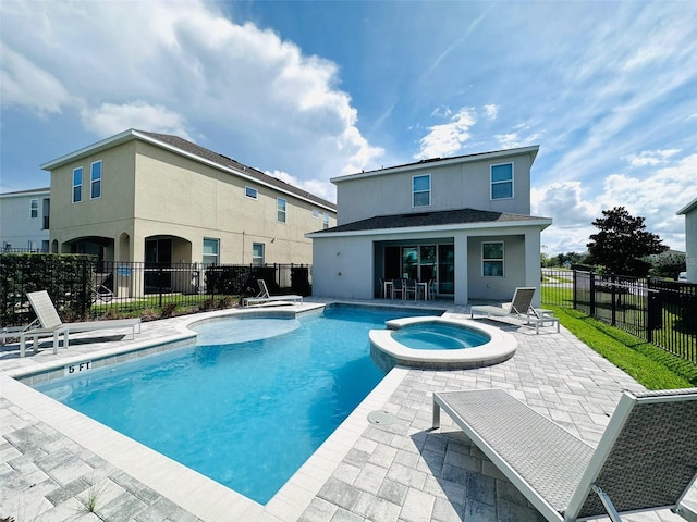 view of pool featuring a patio area, fence, and a pool with connected hot tub