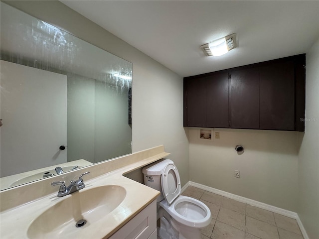 bathroom featuring baseboards, vanity, toilet, and tile patterned floors