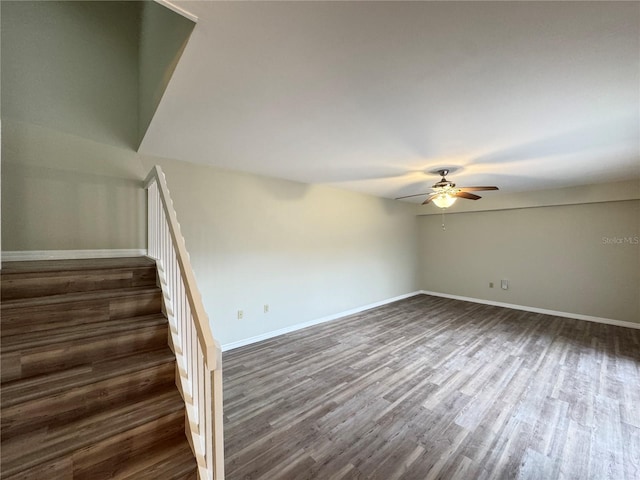 stairs with wood finished floors, a ceiling fan, and baseboards