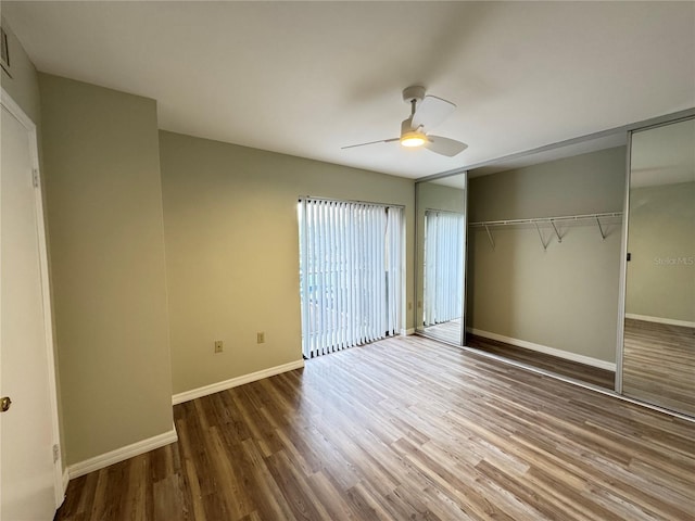 unfurnished bedroom with ceiling fan, a closet, wood finished floors, and baseboards