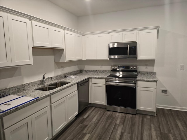 kitchen featuring dark wood-type flooring, a sink, light stone counters, white cabinetry, and stainless steel appliances