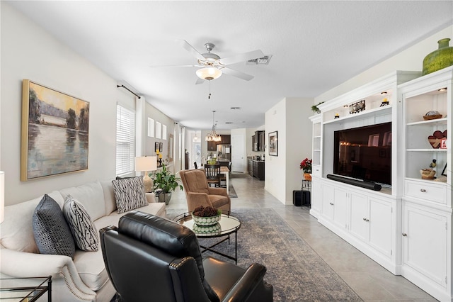 living area with light tile patterned flooring, visible vents, and ceiling fan