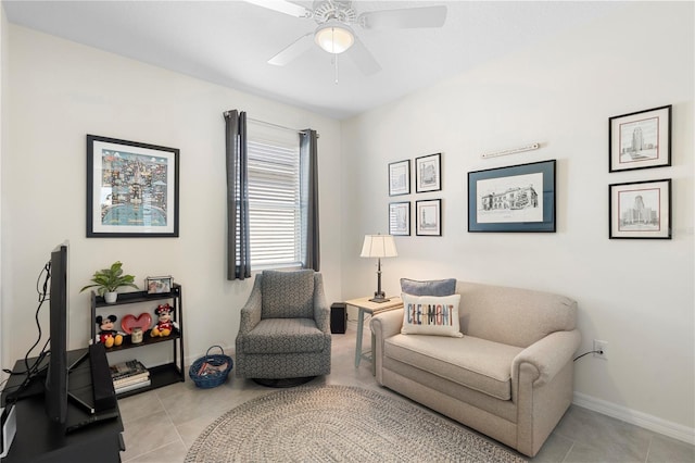 living area featuring light tile patterned flooring, baseboards, and ceiling fan