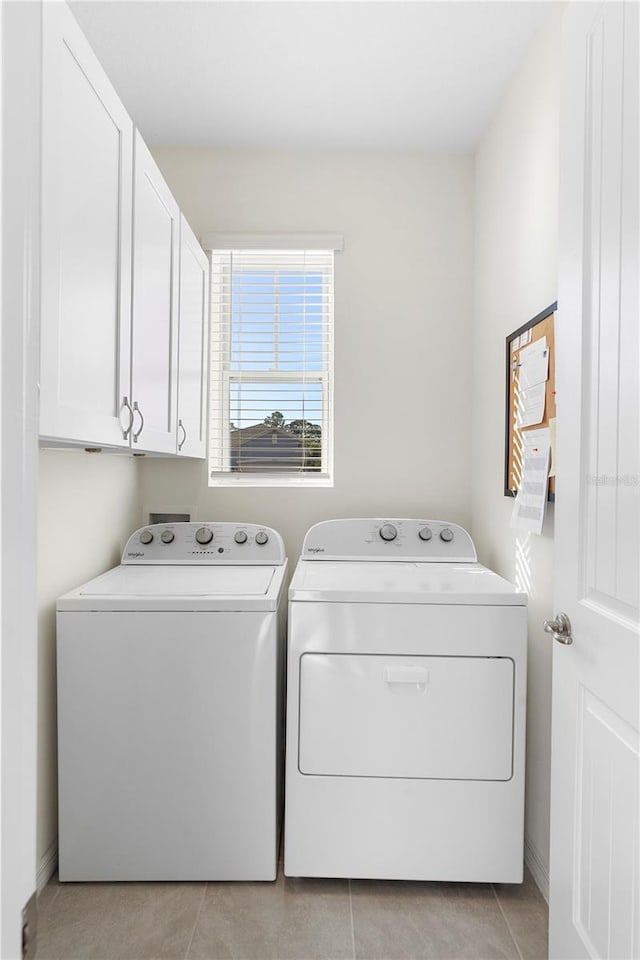 washroom featuring light tile patterned flooring, cabinet space, independent washer and dryer, and baseboards