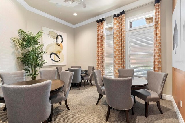 dining space featuring light carpet, plenty of natural light, baseboards, and ornamental molding