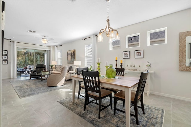 dining space featuring ceiling fan with notable chandelier, light tile patterned floors, baseboards, and visible vents