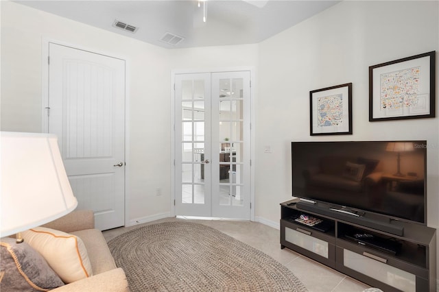 living room with light tile patterned floors, visible vents, french doors, and baseboards