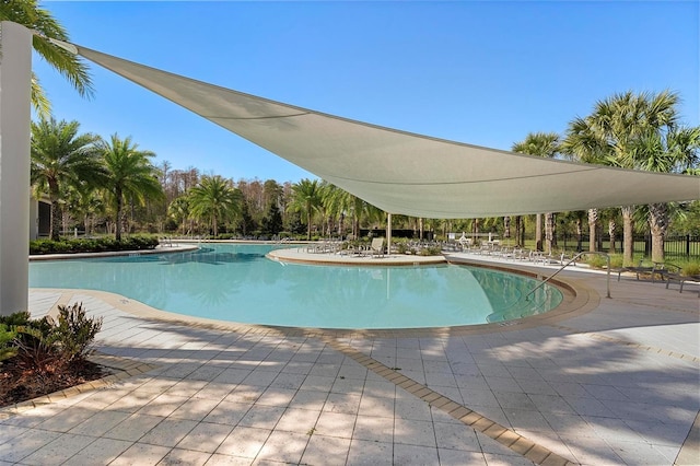 community pool featuring fence and a patio area