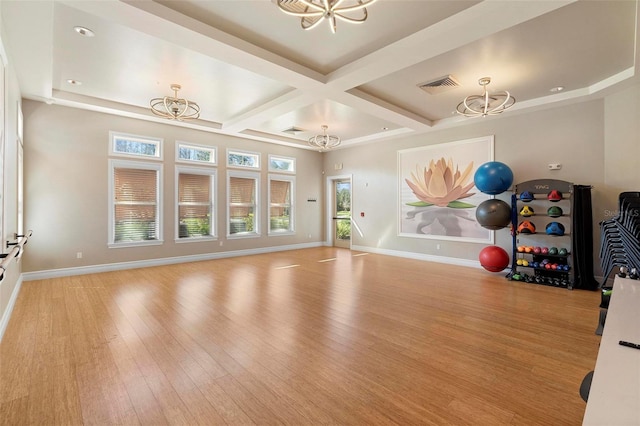 workout room with wood finished floors, baseboards, and a chandelier