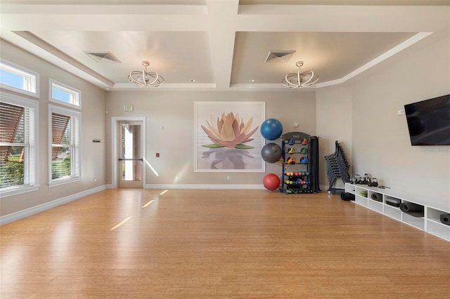 exercise room featuring visible vents, wood finished floors, baseboards, and a chandelier