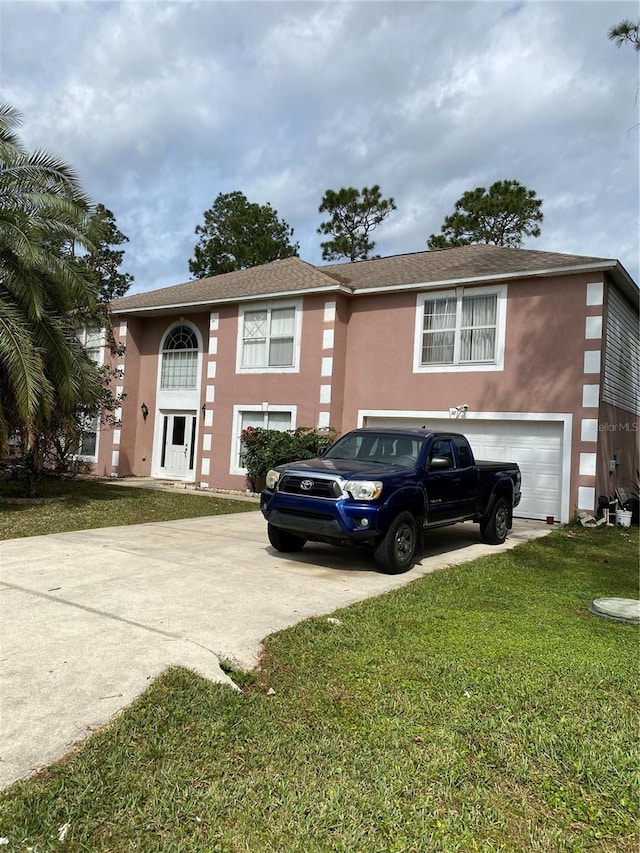 view of front of home featuring stucco siding, an attached garage, concrete driveway, and a front lawn