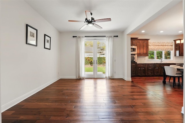 interior space featuring dark wood-style floors, recessed lighting, a sink, and baseboards