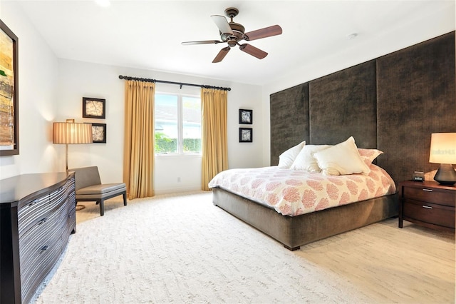 bedroom featuring light carpet and a ceiling fan