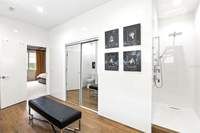 bathroom with visible vents, toilet, wood finished floors, walk in shower, and recessed lighting