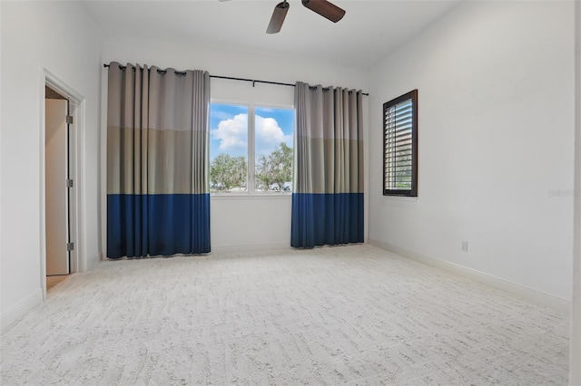 unfurnished room featuring a ceiling fan and baseboards