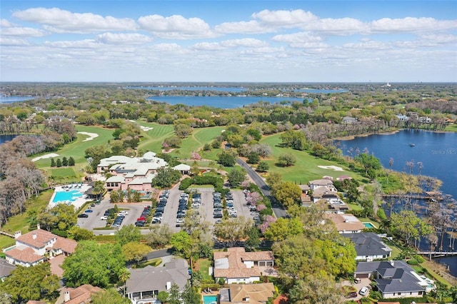 drone / aerial view with view of golf course, a water view, and a residential view