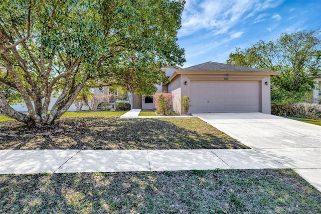 view of front of home with stucco siding, driveway, a front yard, and a garage