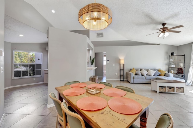 dining room with light tile patterned floors, visible vents, a textured ceiling, and ceiling fan with notable chandelier