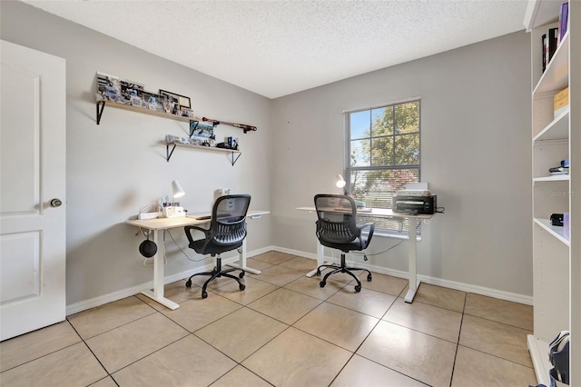 office space featuring light tile patterned floors, baseboards, and a textured ceiling