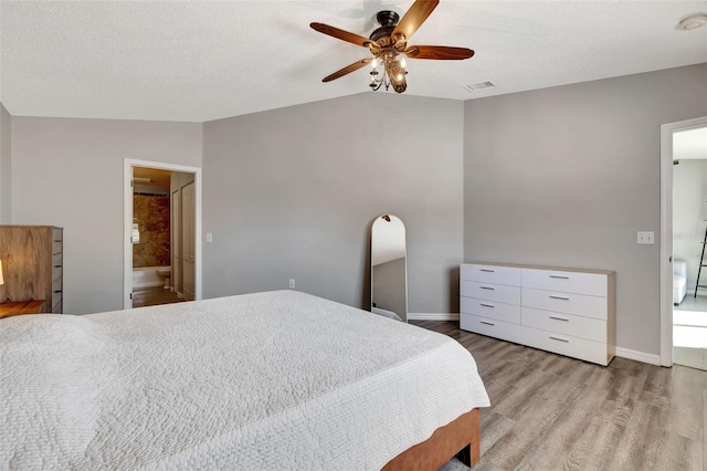 bedroom featuring visible vents, wood finished floors, baseboards, and vaulted ceiling