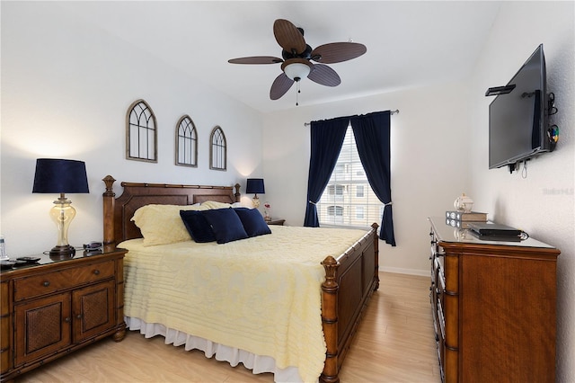 bedroom with light wood finished floors, baseboards, and a ceiling fan