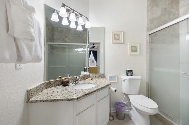 full bath featuring a shower stall, toilet, vanity, and baseboards