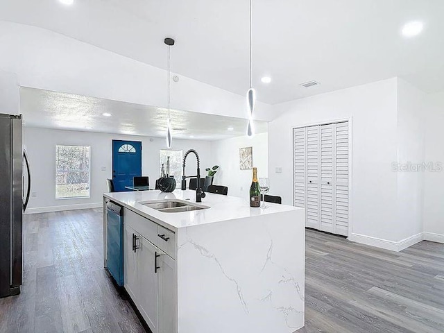 kitchen featuring wood finished floors, a sink, visible vents, baseboards, and appliances with stainless steel finishes