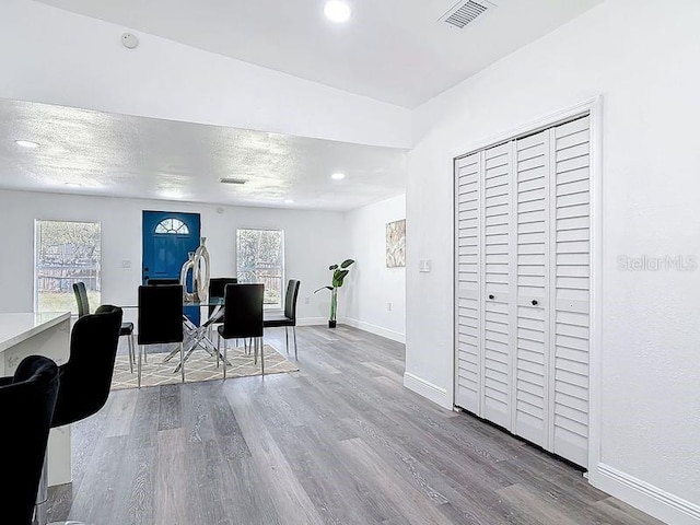 home office featuring recessed lighting, visible vents, a textured ceiling, wood finished floors, and baseboards