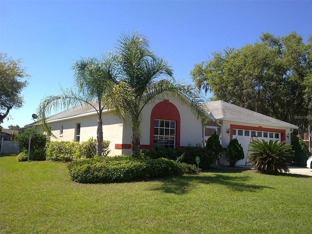 view of front of property with a front lawn, a garage, and stucco siding